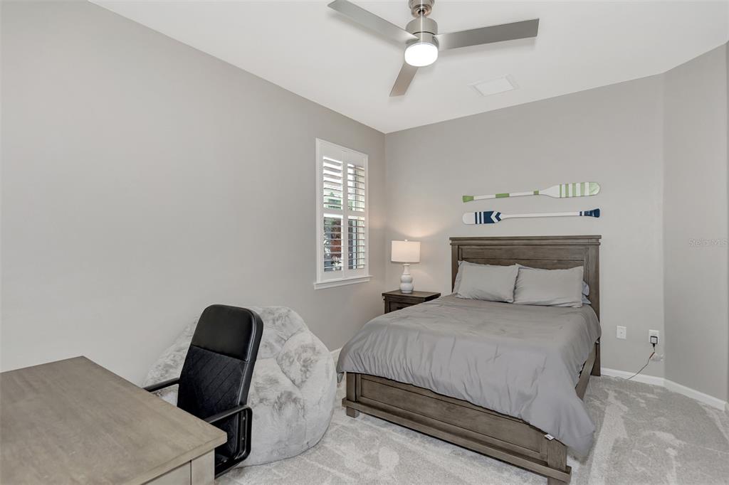 11616 Golden Bay Place Lakewood Ranch, FL 34211 - Photo 33 of 66 a bedroom with a bed and a chandelier