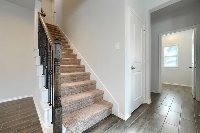 a view of a hallway with wooden floor and entryway