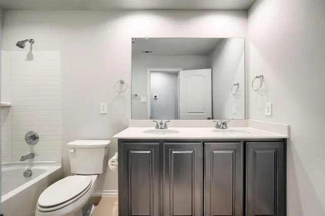 a bathroom with a granite countertop toilet a sink and a mirror