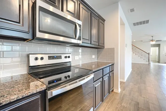 a kitchen with stainless steel appliances granite countertop a stove and a microwave