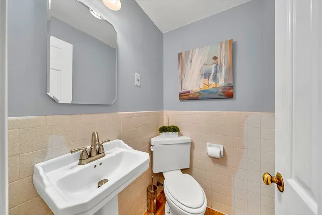 a bathroom with a sink mirror and toilet