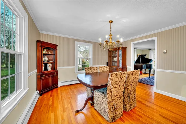 a dining room with chandelier and wooden floor