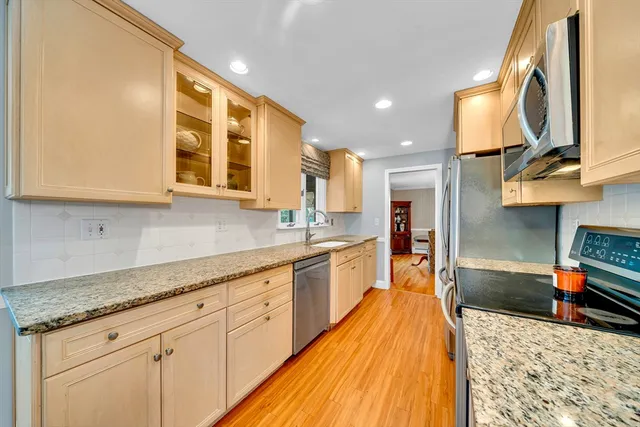 a large kitchen with stainless steel appliances granite countertop a sink and cabinets
