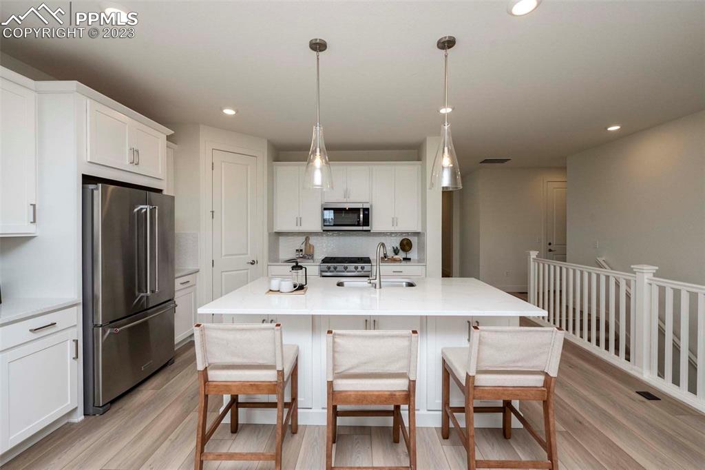 2036 Peachleaf Loop Castle Rock, CO 80108 - Photo 13 of 35 a kitchen with stainless steel appliances granite countertop a dining table chairs refrigerator and sink