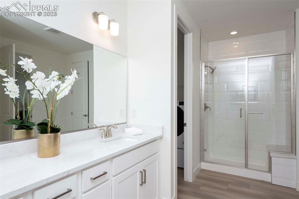 2036 Peachleaf Loop Castle Rock, CO 80108 - Photo 23 of 35 a bathroom with a granite countertop sink a mirror and a shower