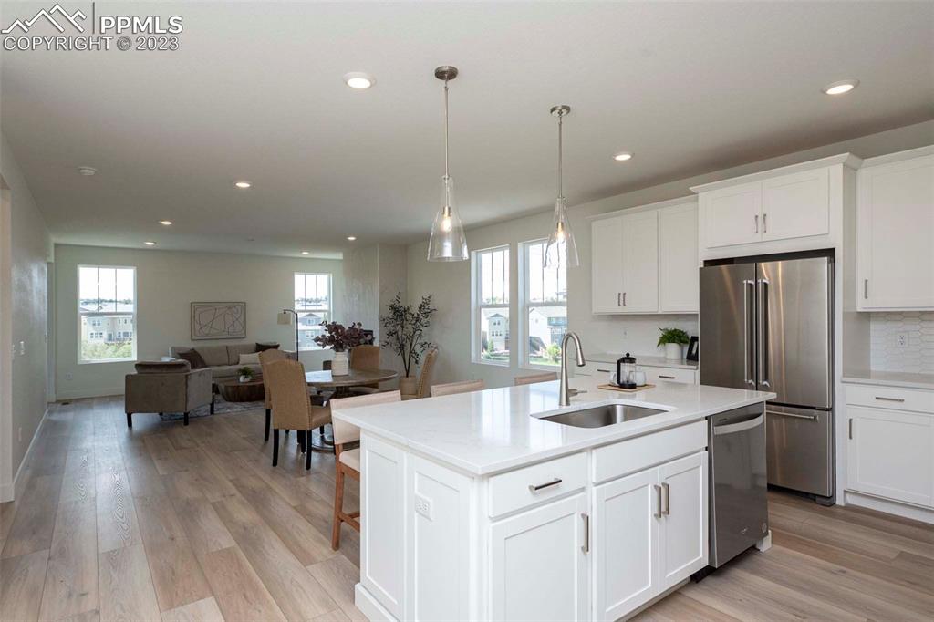 2036 Peachleaf Loop Castle Rock, CO 80108 - Photo 9 of 35 a kitchen with stainless steel appliances a dining table chairs refrigerator and sink