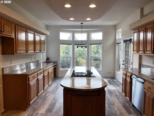 a kitchen with stainless steel appliances granite countertop a sink a stove and a refrigerator