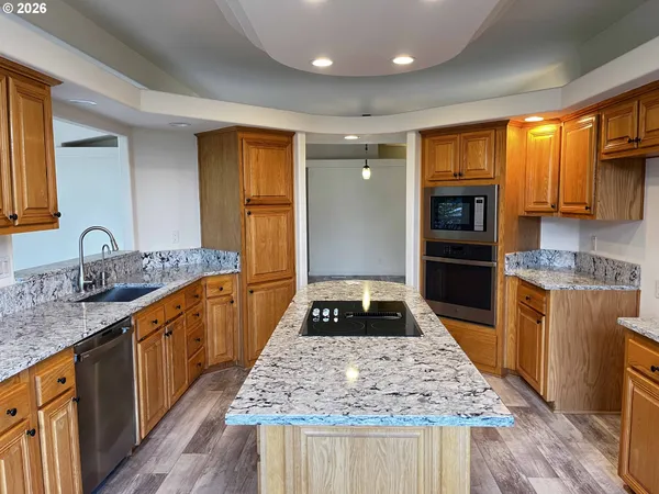 a kitchen with kitchen island granite countertop a stove and a sink