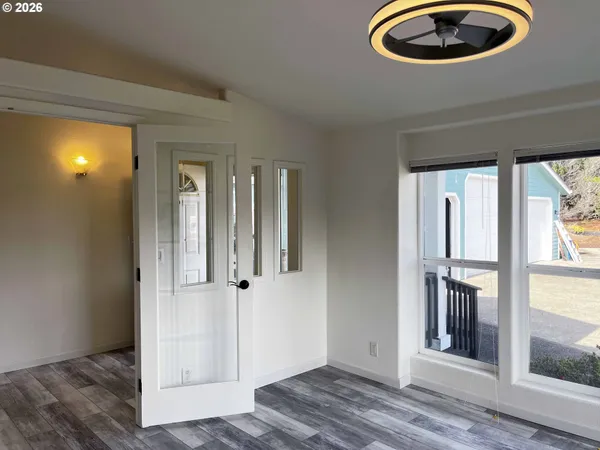 an entryway to room with wooden floor and windows