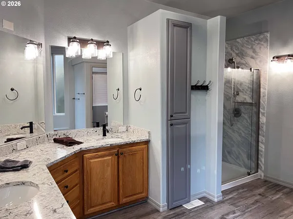 a bathroom with a granite countertop sink shower and a mirror