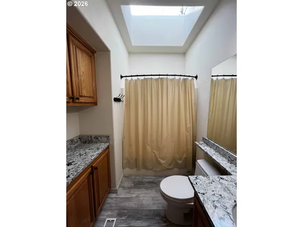 a bathroom with a granite countertop sink toilet and shower