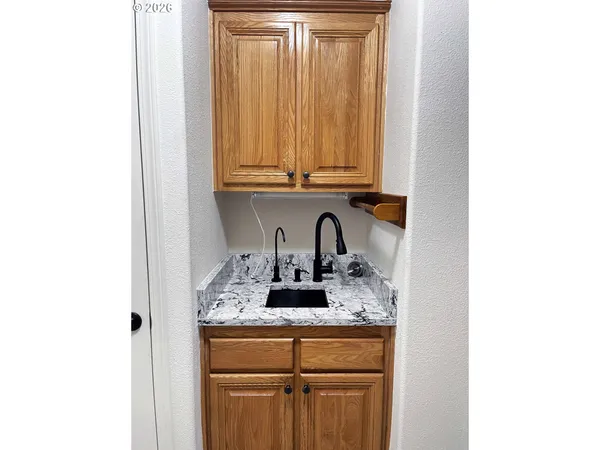 a kitchen with granite countertop white cabinets and a sink