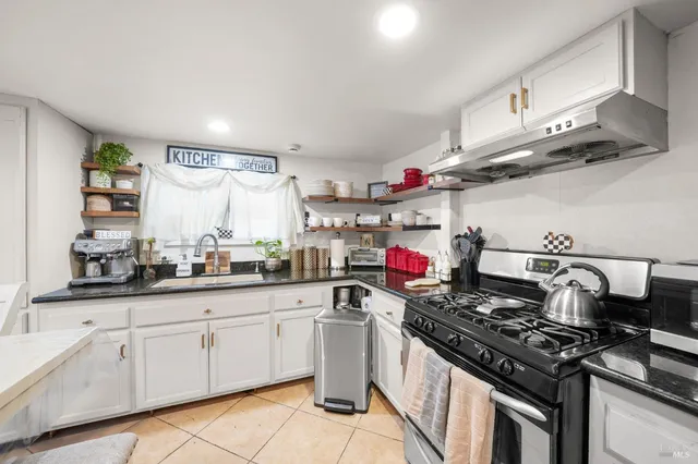 a kitchen with granite countertop a sink and cabinets