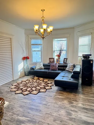 a living room with furniture and a chandelier