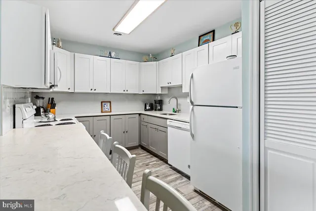 a kitchen with white cabinets and white appliances