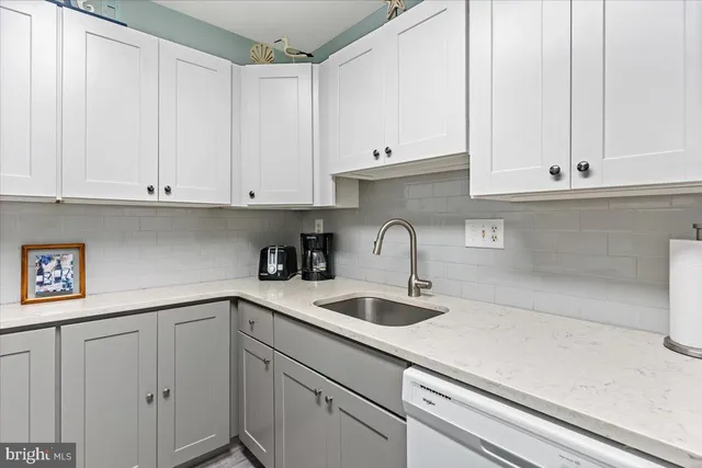 a kitchen with white cabinets and a sink