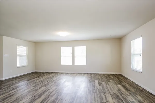 an empty room with wooden floor and window