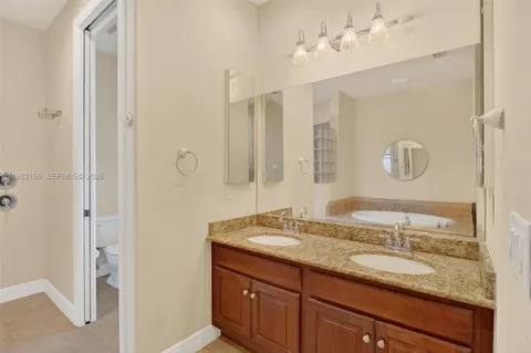 a bathroom with a granite countertop sink a mirror and a shower