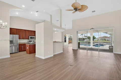 a view of kitchen with stainless steel appliances a refrigerator and wooden floor