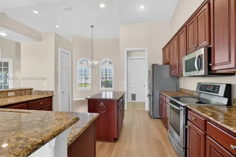 a kitchen with granite countertop a sink stove and refrigerator