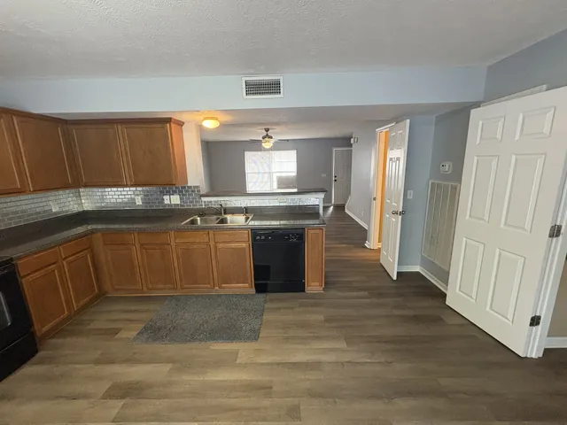 a kitchen with stainless steel appliances granite countertop a stove a sink dishwasher and a refrigerator