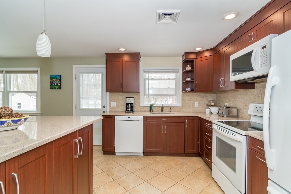 136 Parker Road Framingham, MA 01702 - Photo 2 of 32 a kitchen with stainless steel appliances granite countertop a sink and dishwasher a stove top oven with wooden floor