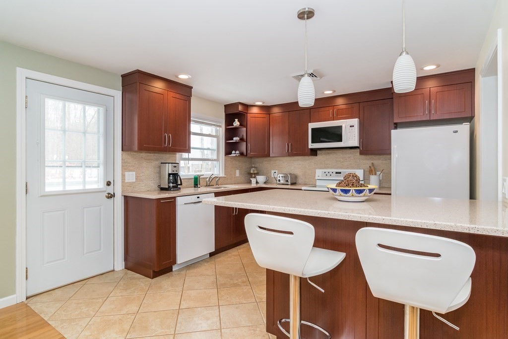 136 Parker Road Framingham, MA 01702 - Photo 3 of 32 a kitchen with stainless steel appliances granite countertop a sink a stove a refrigerator a microwave oven with white cabinets and wooden floor