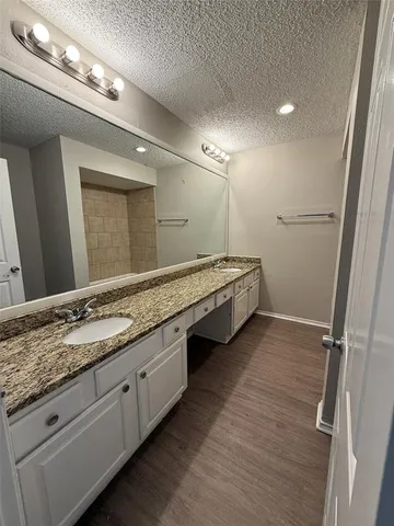 a spacious bathroom with double vanity and a mirror