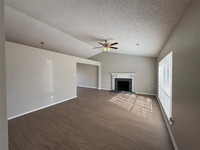 a view of an empty room with a fireplace and a window