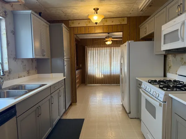 a kitchen with stainless steel appliances granite countertop a sink a stove and a refrigerator