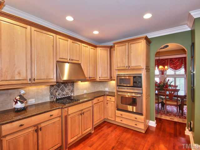 10149 Darling Street Raleigh, NC 27613 - Photo 5 of 25 a kitchen with stainless steel appliances granite countertop a stove a sink and a refrigerator