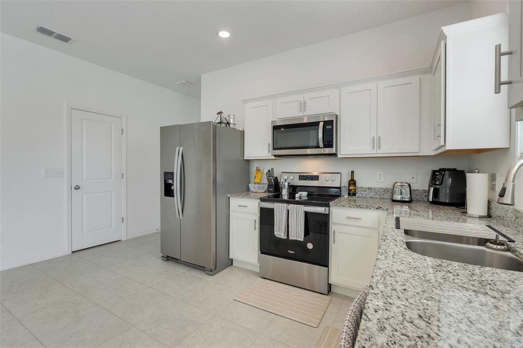 3270 Water Sprite Street Orlando, FL 32808 - Photo 12 of 34 a kitchen with stainless steel appliances granite countertop a refrigerator stove a sink and dishwasher