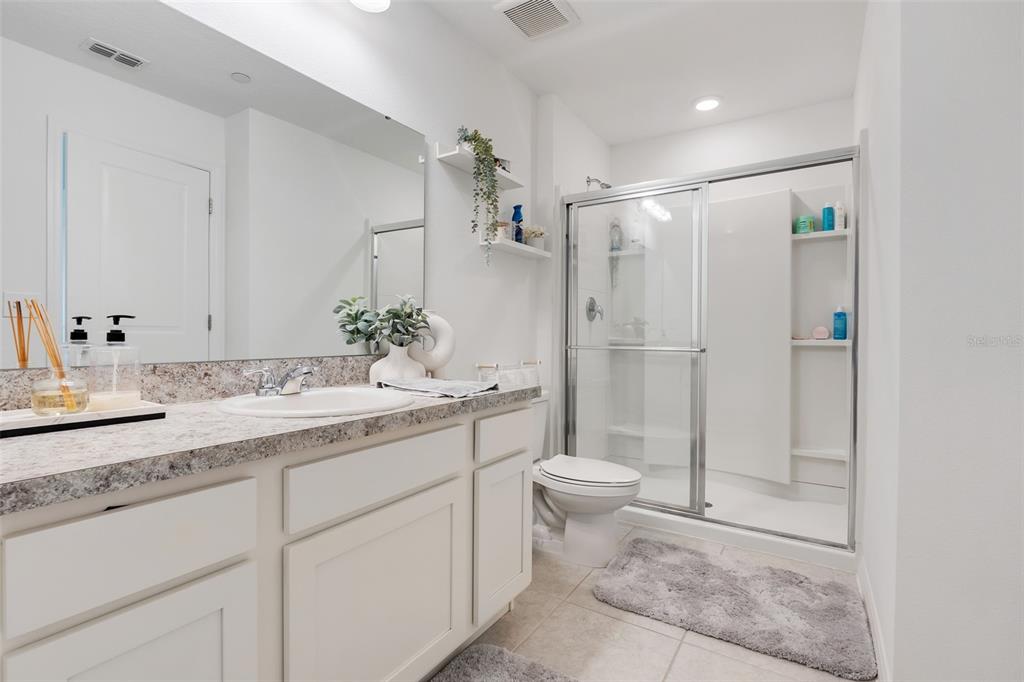 3270 Water Sprite Street Orlando, FL 32808 - Photo 19 of 34 a bathroom with a granite countertop sink a toilet and shower