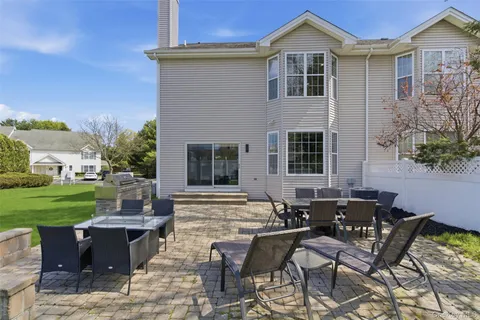 a view of a dinning table and chairs in backyard of the house