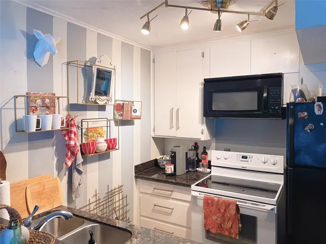 a kitchen with stainless steel appliances kitchen island granite countertop a stove and a microwave