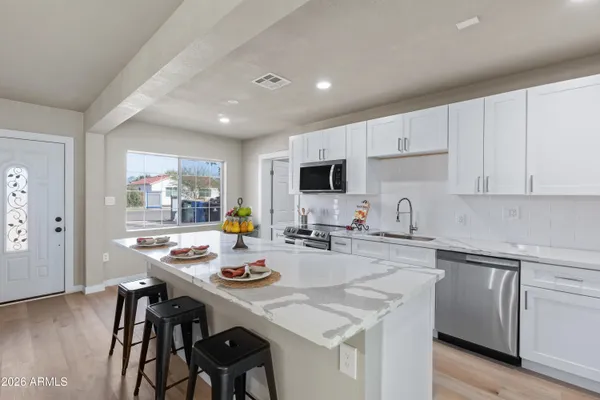 a kitchen with a sink white cabinets and stainless steel appliances