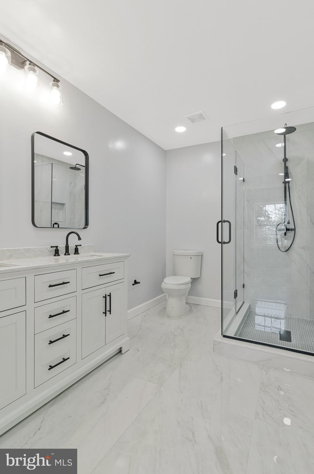7269 Evanston Road Springfield, VA 22150 - Photo 25 of 41 a bathroom with a double vanity sink a toilet a mirror and shower