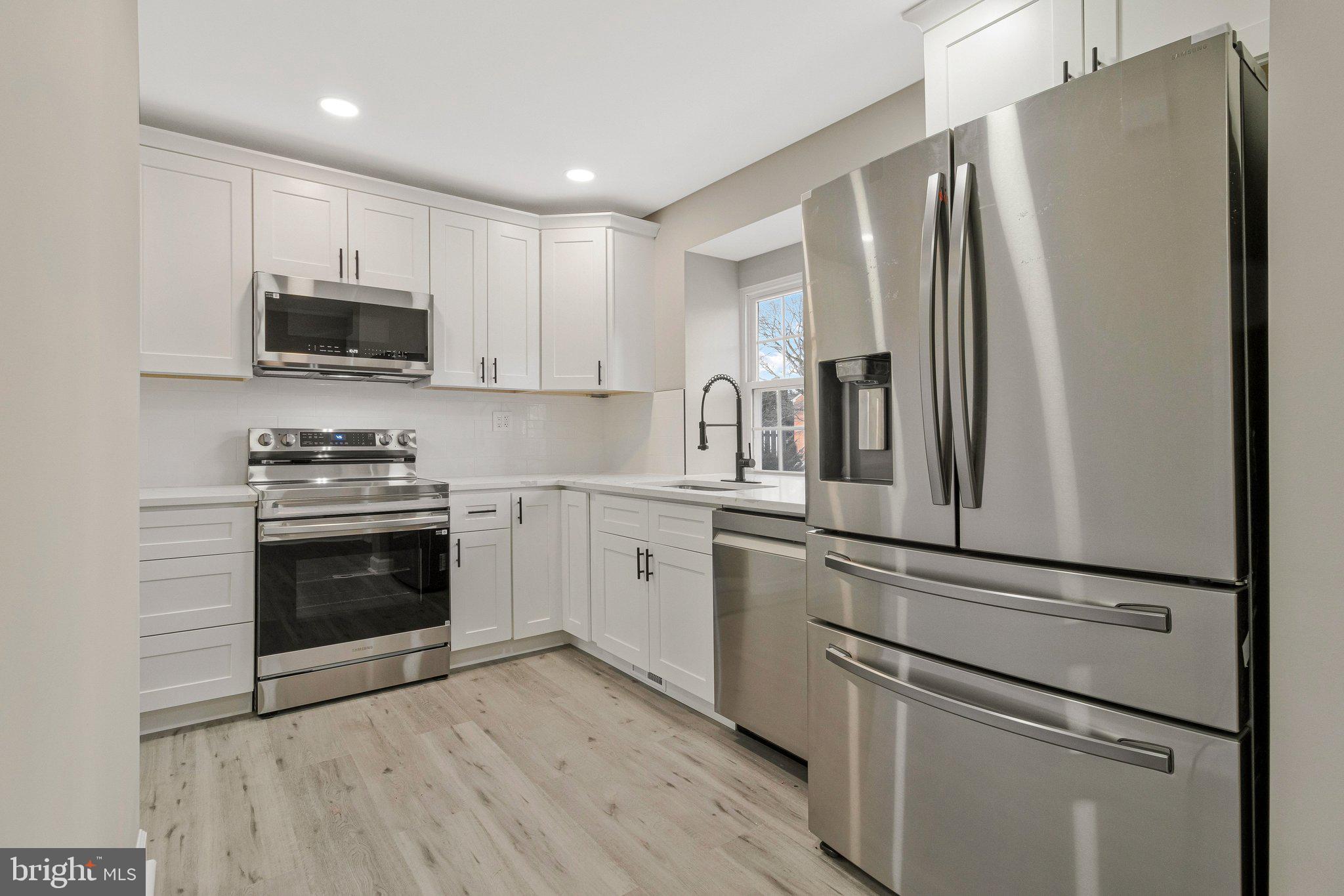 7269 Evanston Road Springfield, VA 22150 - Photo 4 of 41 a kitchen with cabinets stainless steel appliances and wooden floor