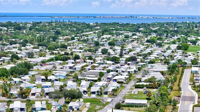 an aerial view of residential houses with outdoor space and trees
