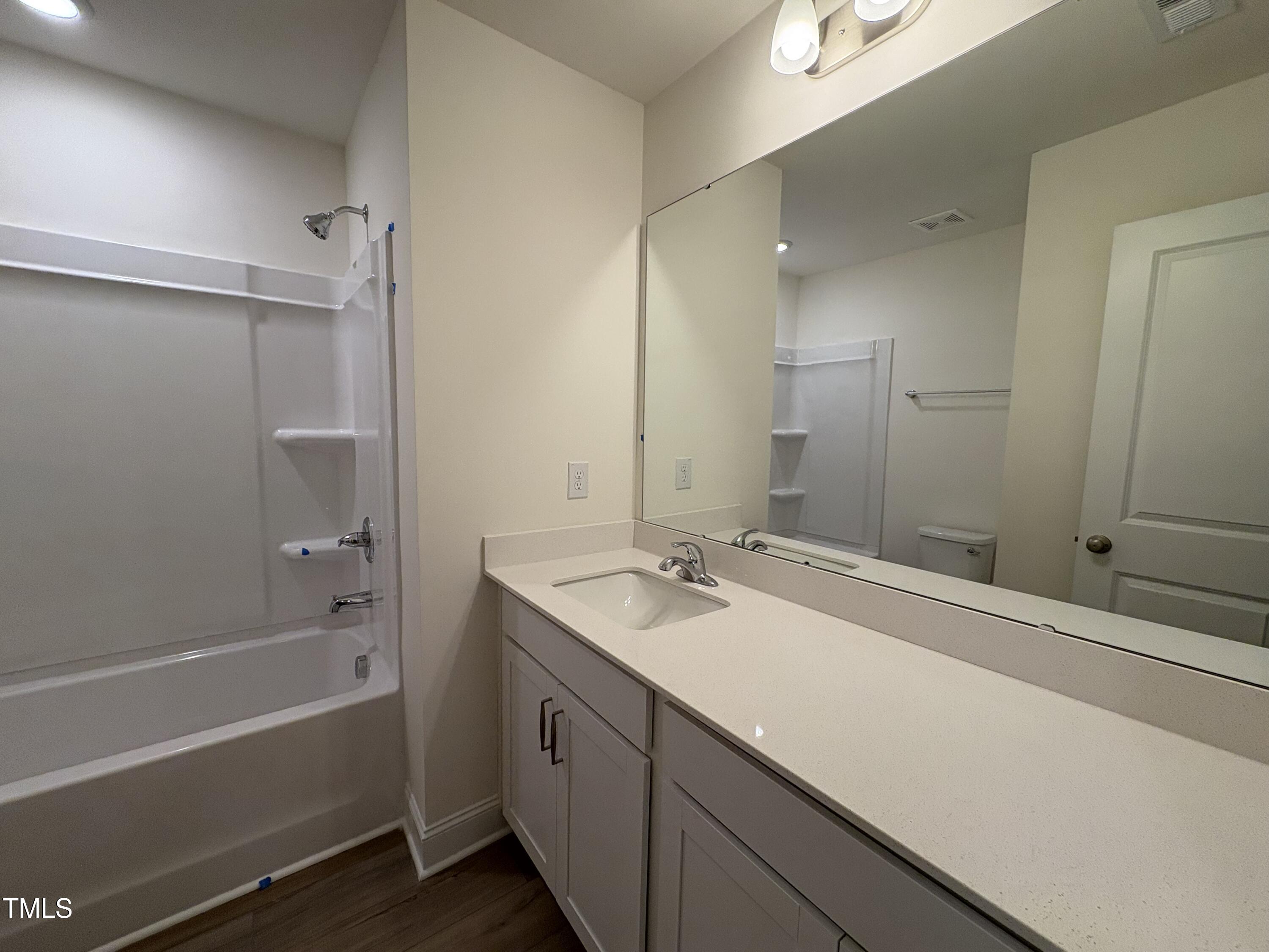 6316 Granite Quarry Drive Raleigh, NC 27610 - Photo 10 of 16 a bathroom with a granite countertop sink mirror and a bath tub
