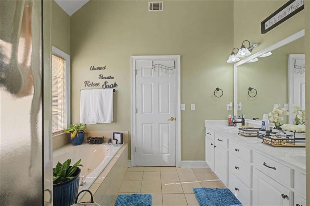9620 Coastal Pointe Drive Villa Rica, GA 30180 - Photo 51 of 65 a spacious bathroom with a double vanity sink a mirror and a shower