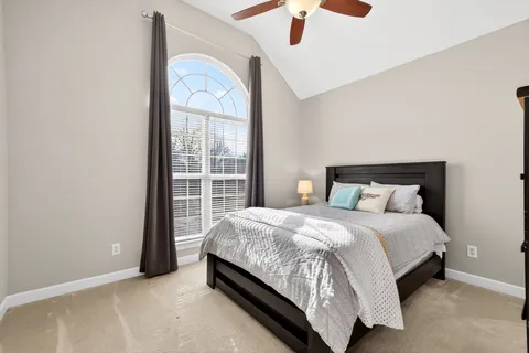 a large bed sitting in a bedroom next to a window