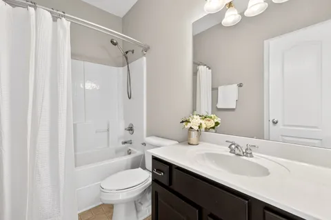 a bathroom with a granite countertop sink toilet a large mirror a shower and a bathtub