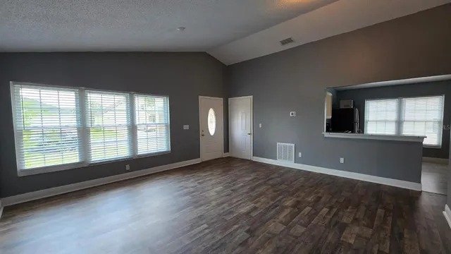 a kitchen with granite countertop a stove and a wooden floors