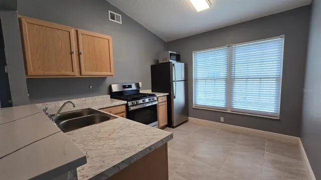 a kitchen with white cabinets and white stainless steel appliances and refrigerator