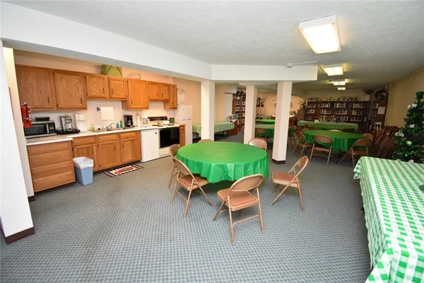 a living room with furniture a fireplace and a kitchen view