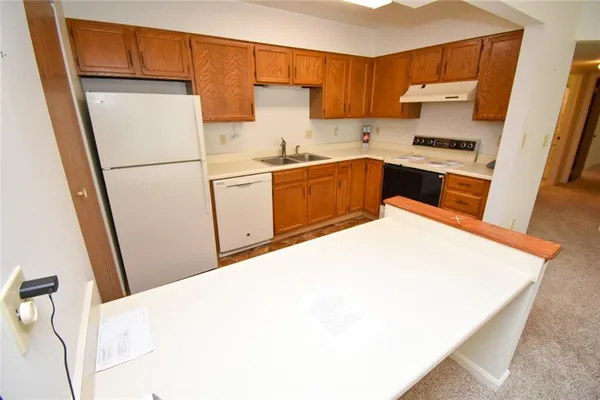 a kitchen with a sink a refrigerator a microwave and cabinets