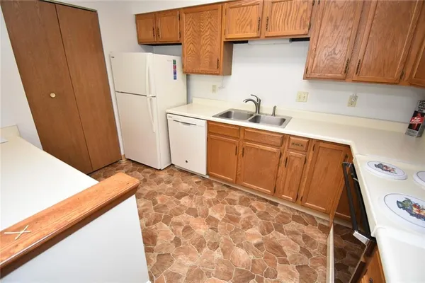a kitchen with a sink a refrigerator and cabinets