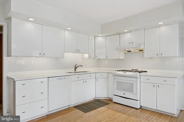 a kitchen with granite countertop white cabinets and white appliances