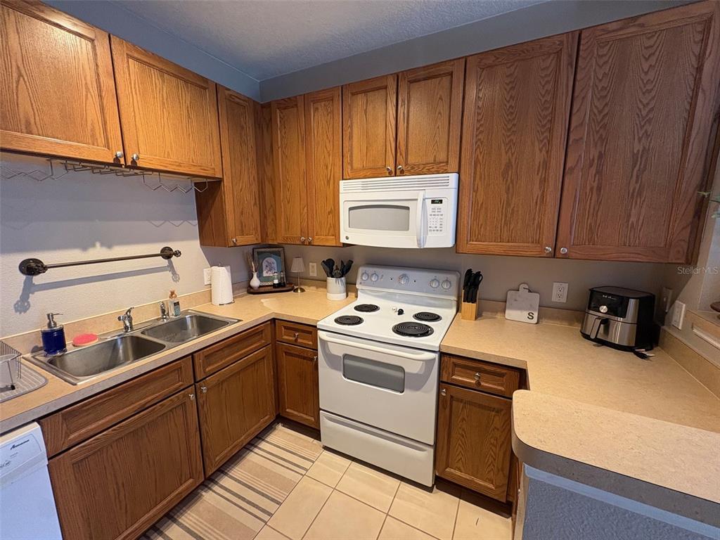 10106 Regent Square Drive, Unit 209 Orlando, FL 32825 - Photo 4 of 19 a kitchen with sink cabinets and stove top oven